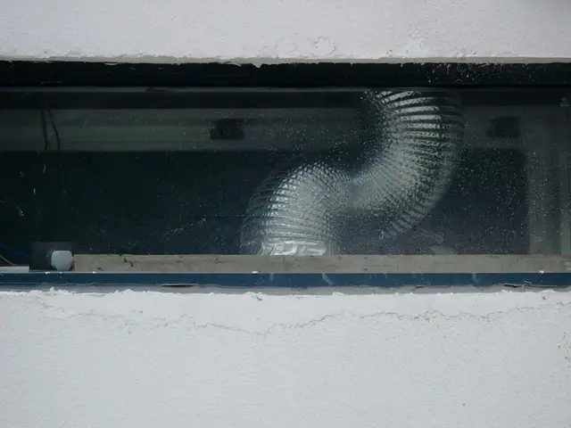 A flexible ventilation duct visible through a small rectangular window.